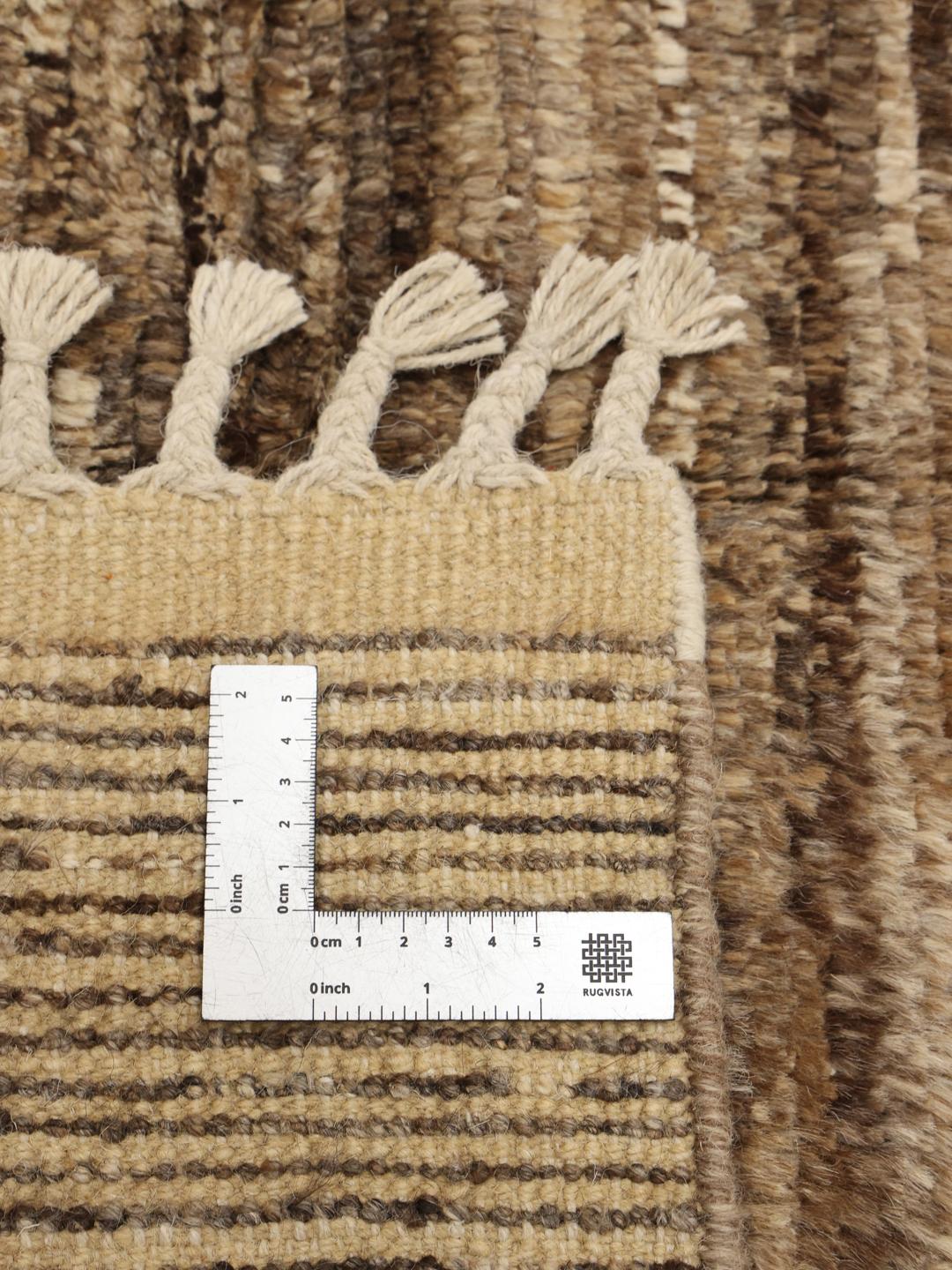 Un tapis afghan noué à la main présentant un motif géométrique dans des tons marron terreux.