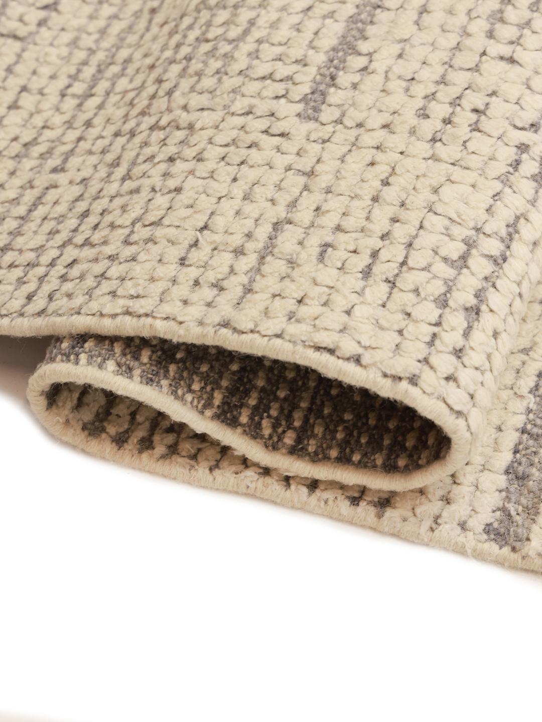 Un grand tapis style berbère noué à la main provenant d'Afghanistan, arborant un motif de lignes géométriques dans des tons beige et marron neutres.