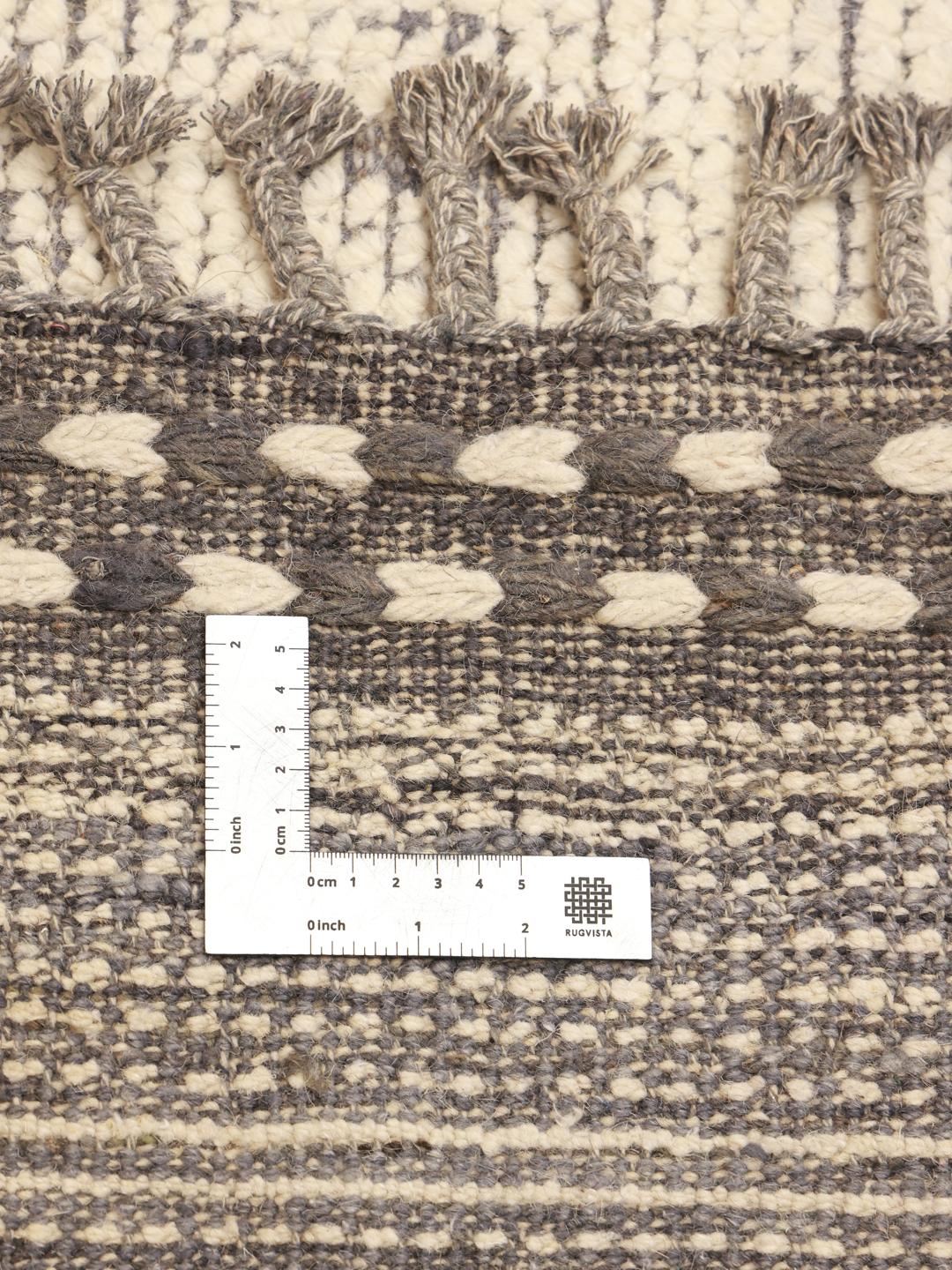 Un grand tapis style berbère noué à la main provenant d'Afghanistan, arborant un motif de lignes géométriques dans des tons beige et marron neutres.