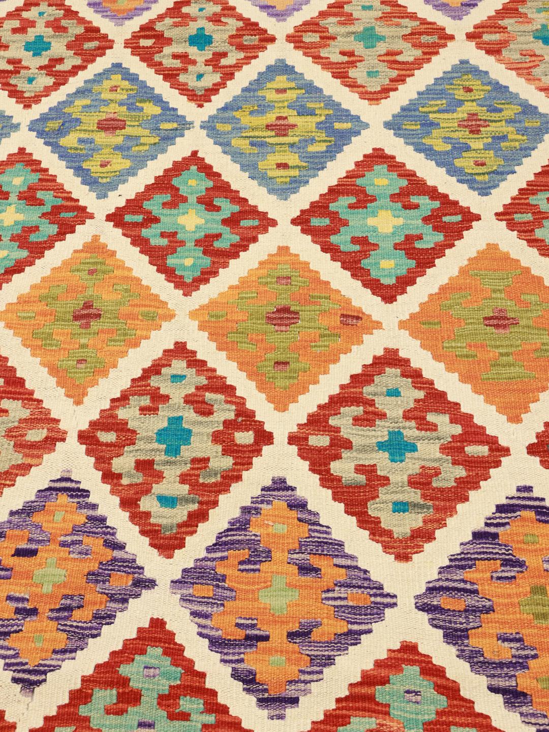 Een levendig, handgeweven Afghan Kelim vloerkleed met een kleurrijk geometrisch ruitpatroon.