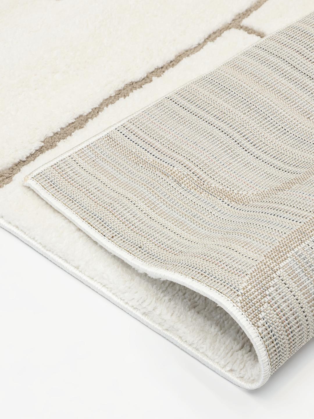 Hvidt og beige tæppe med design i høj og lav luv