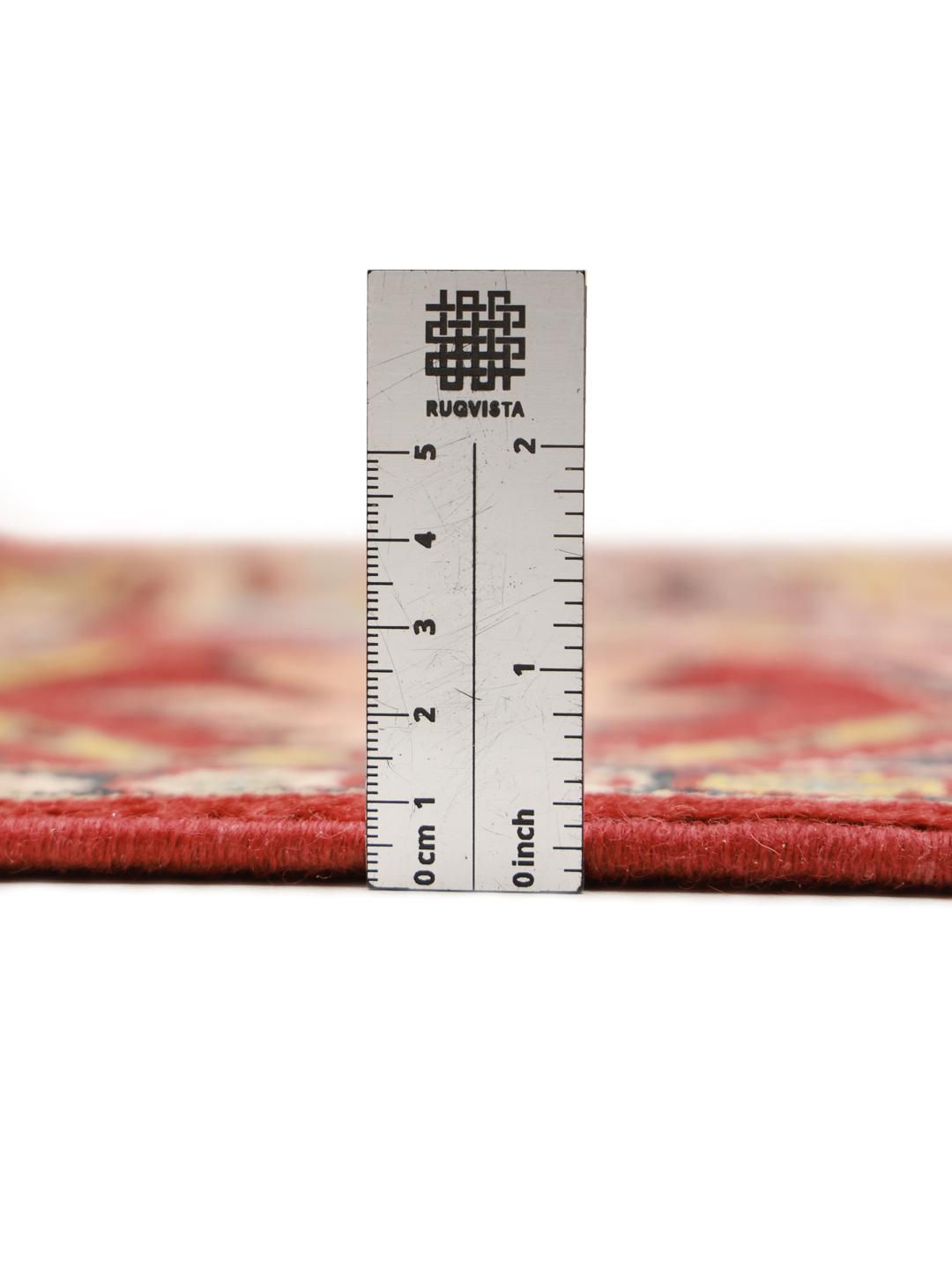 A hand-knotted Kazak rug from Afghanistan with a vibrant red field and geometric patterns.