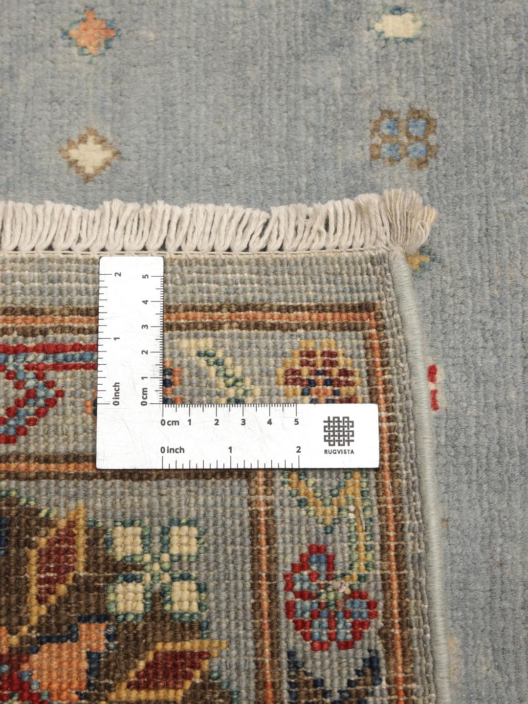 Covor afgan Kazak înnodat manual, de culoare albastru deschis, cu motive geometrice tradiționale.
