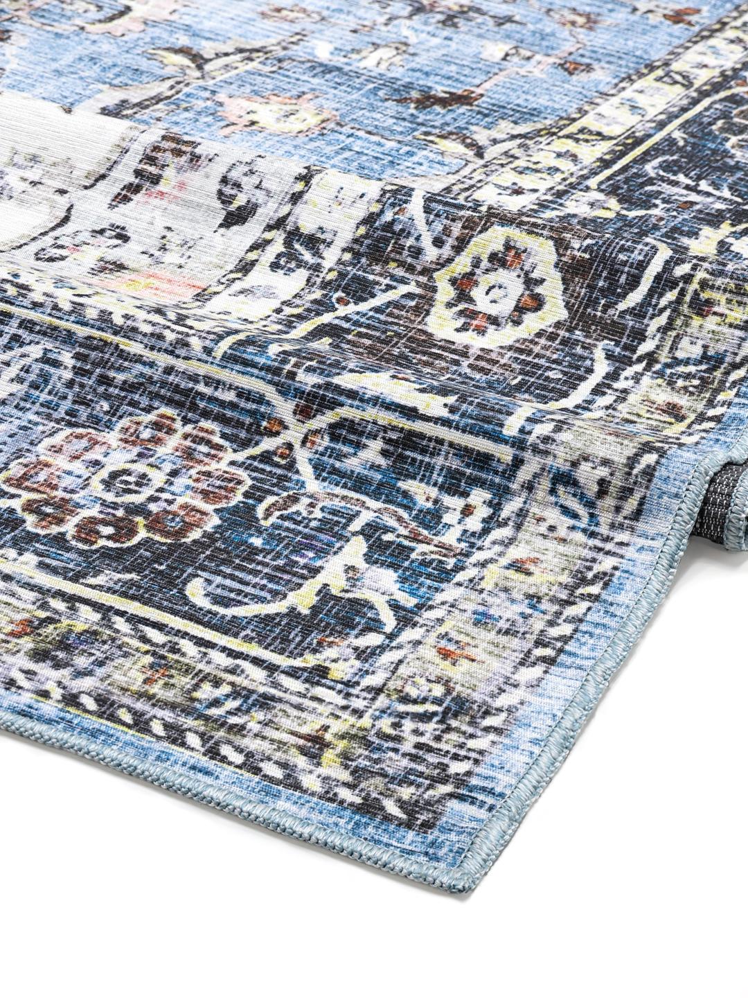 Blauw tapijt met traditionele motieven en een gedetailleerde rand