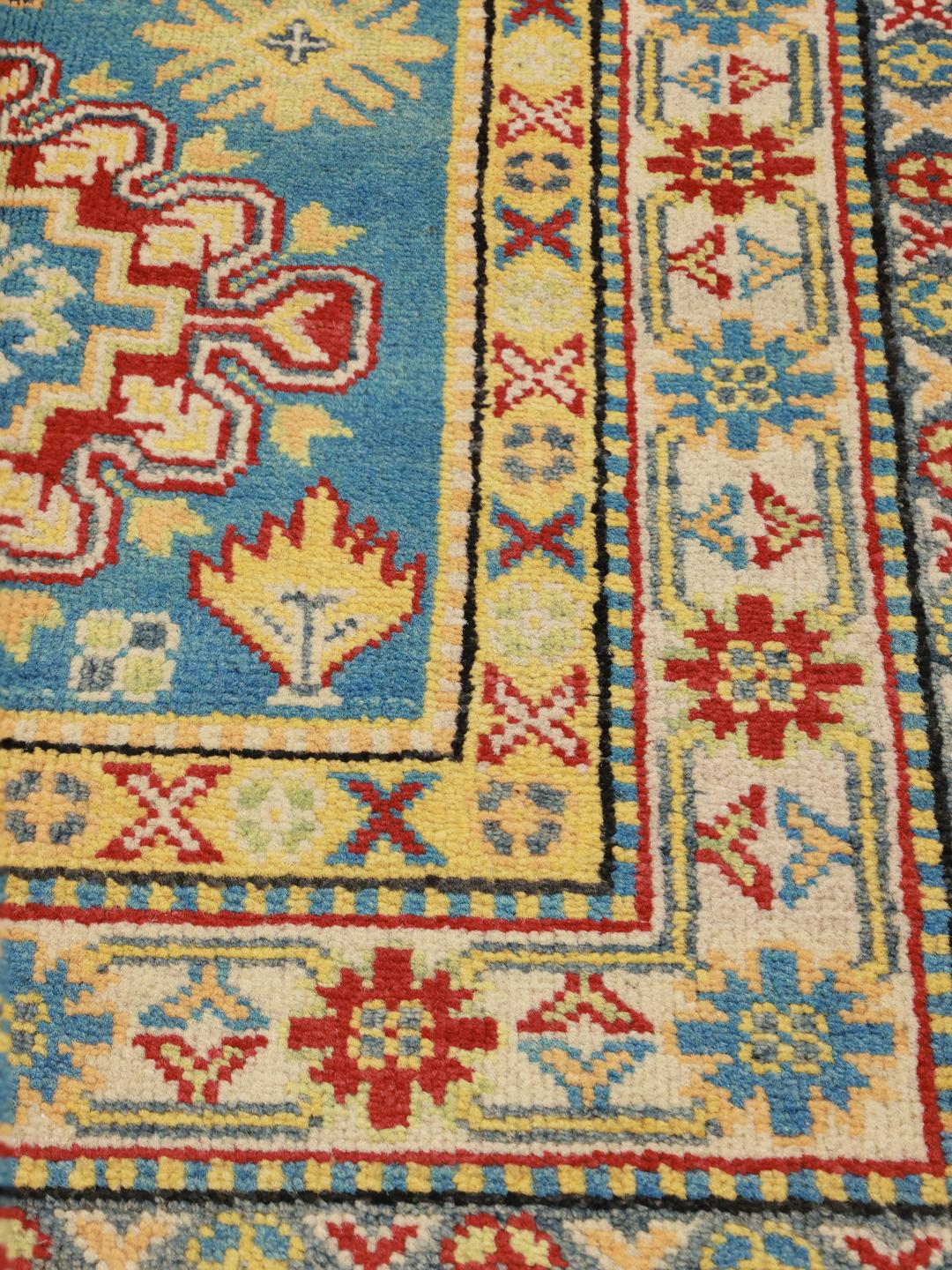 Een handgeknoopt blauw Kazak loper tapijt uit Afghanistan met geometrische patronen.