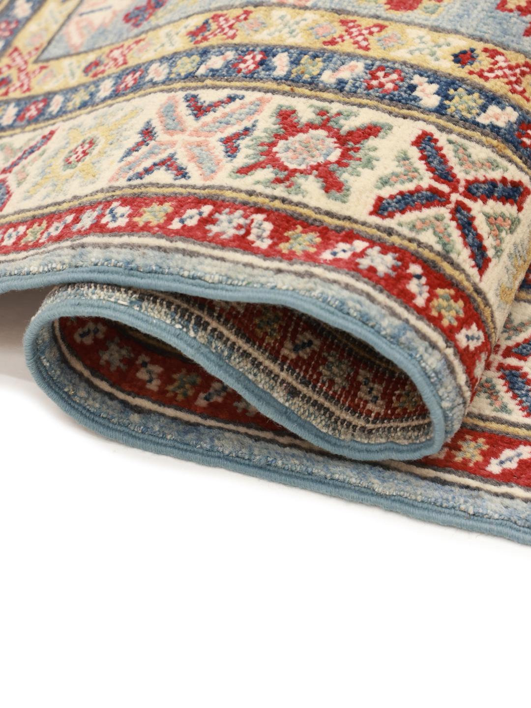 Un tapis couloir Kazak noué à la main en provenance d'Afghanistan présentant des motifs géométriques en bleu, rouge et crème.