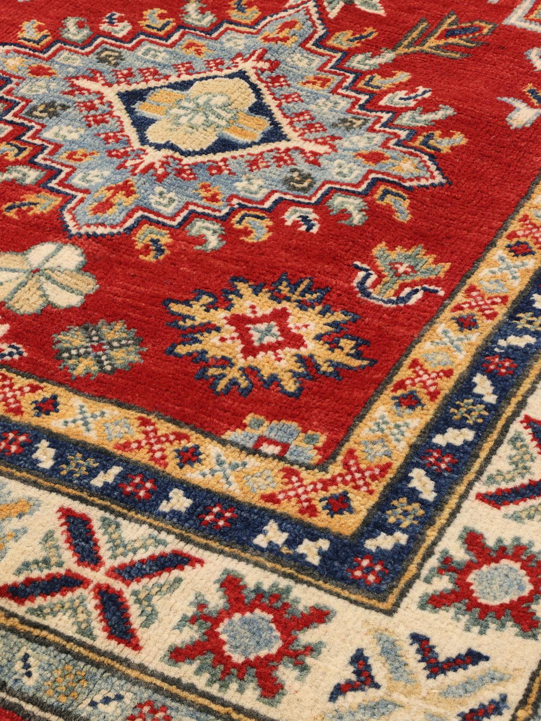 Ein langer, roter, handgeknüpfter Kazak-Läufer mit geometrischen Medaillons aus Afghanistan.