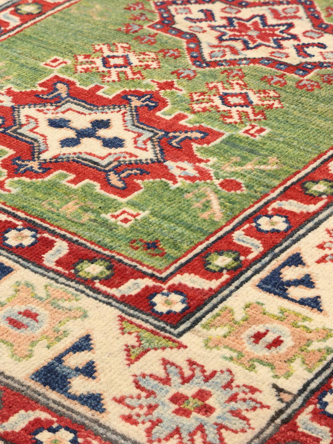 Handgeknüpfter Kazak-Teppich aus Afghanistan mit einem lebendigen grünen Feld und geometrischen Mustern.