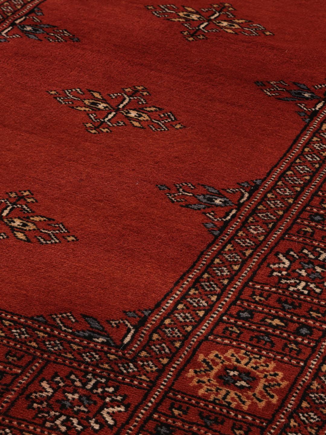 Hand-knotted Pakistan Bokhara runner in deep red with traditional motifs.