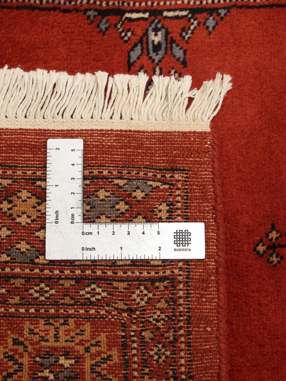 Hand-knotted Pakistan Bokhara runner in deep red with traditional motifs.