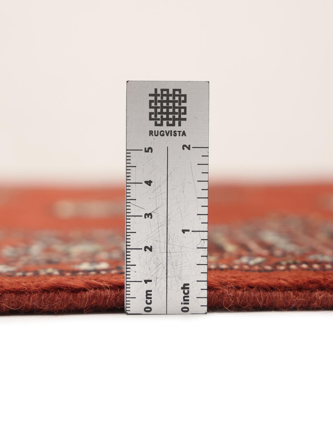 Hand-knotted Pakistan Bokhara rug with a vibrant red field and traditional geometric motifs