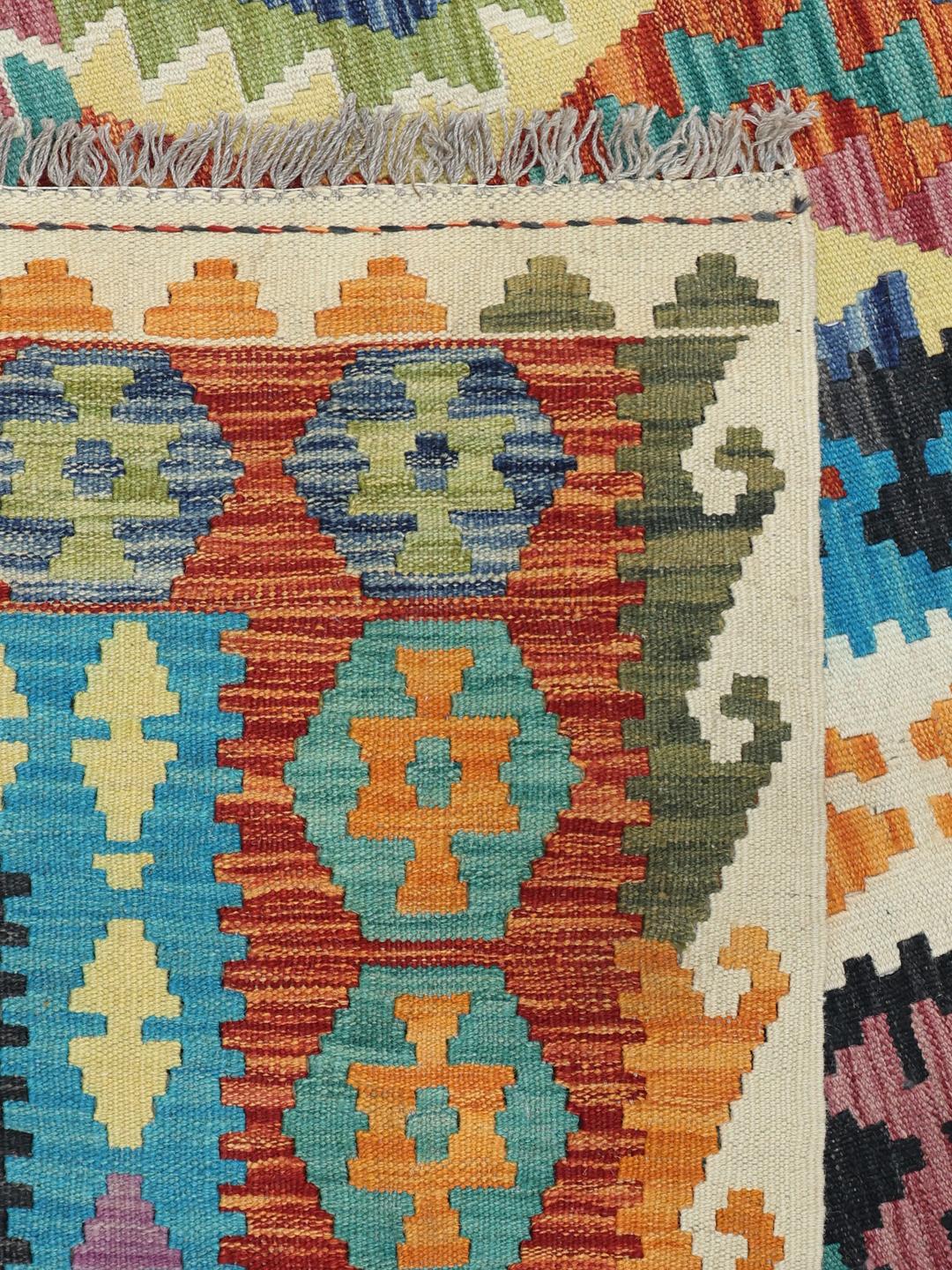 Hand-woven Afghan Kelim rug with vibrant geometric patterns and a multicolor palette