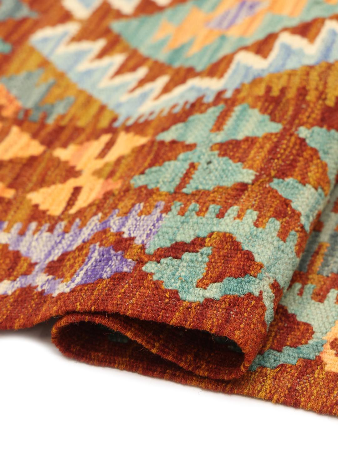 Un tapis Kelim afghan rectangulaire tissé à la main présentant un motif en losange vibrant et multicolore.