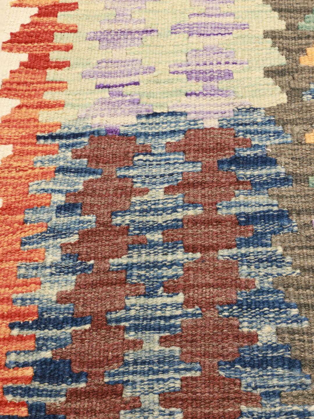 Tapis Kelim afghan tissé à la main avec un motif géométrique dans des tons terreux.