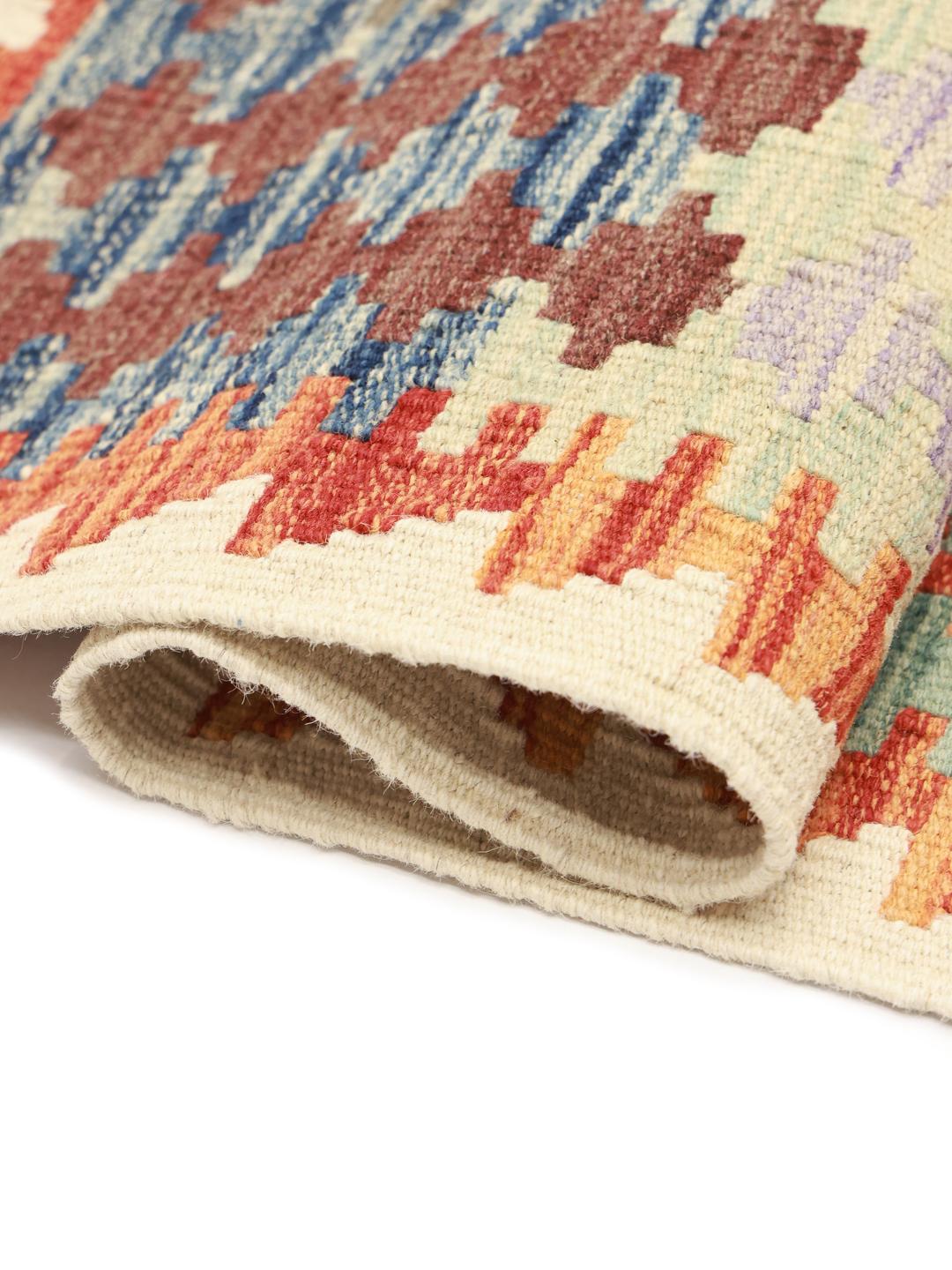 Tapis Kelim afghan tissé à la main avec un motif géométrique dans des tons terreux.