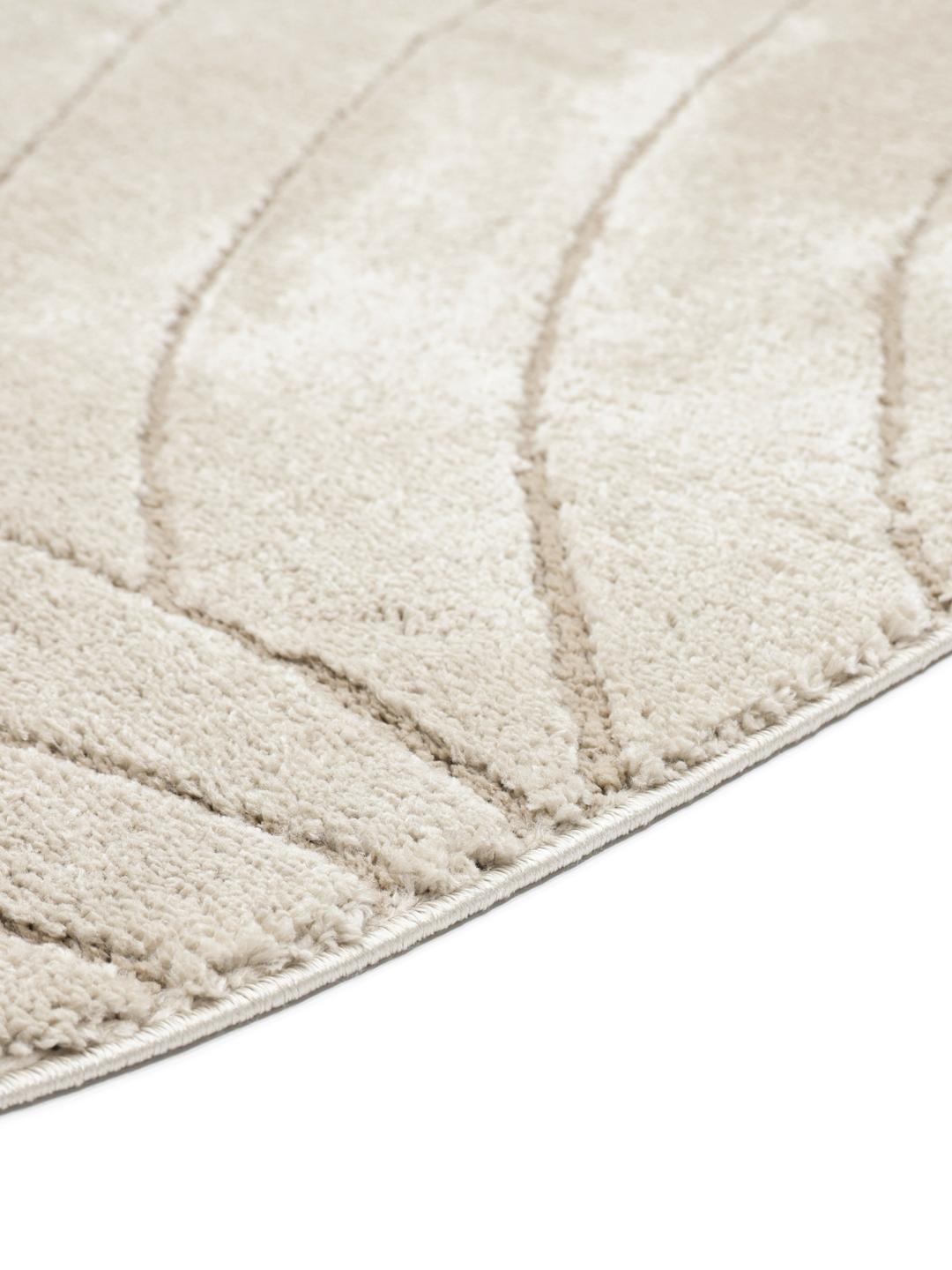 Rond beige tapijt met een textuur van hoge en lage polen