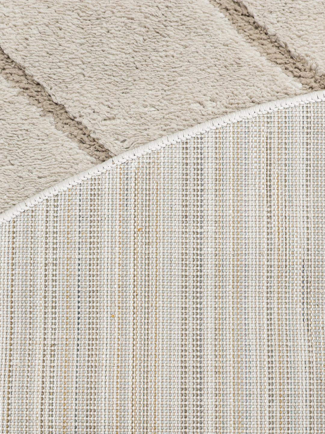 Rond beige tapijt met een textuur van hoge en lage polen