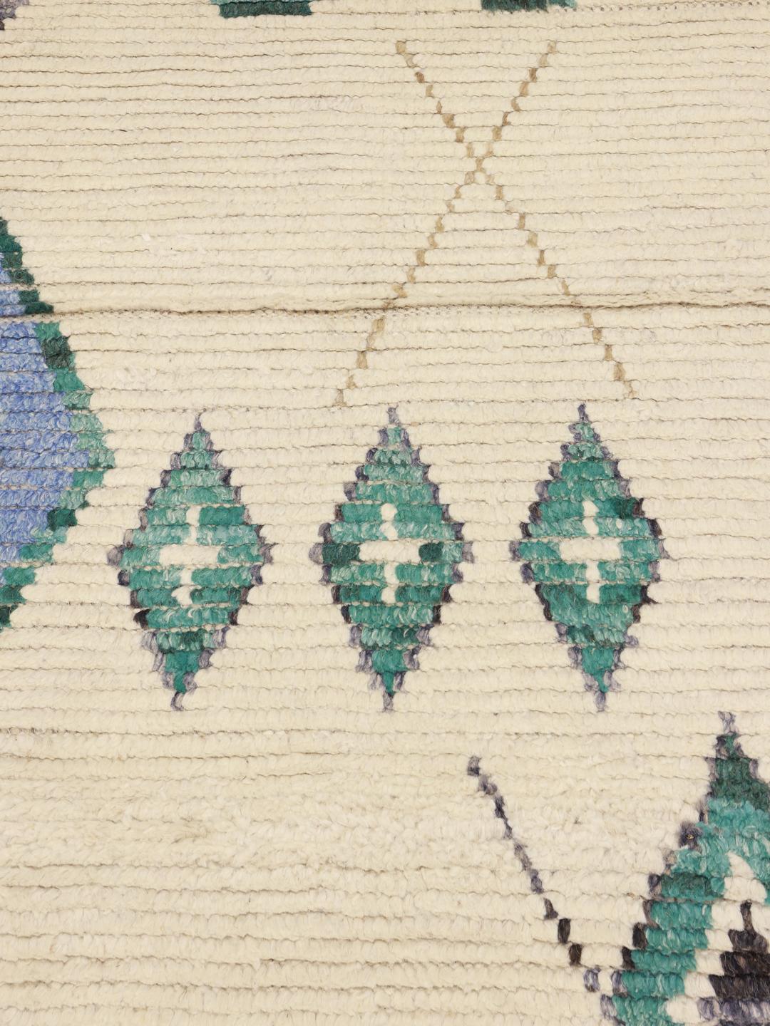Hand-knotted Afghan rug with geometric diamond patterns in beige, blue, and green.
