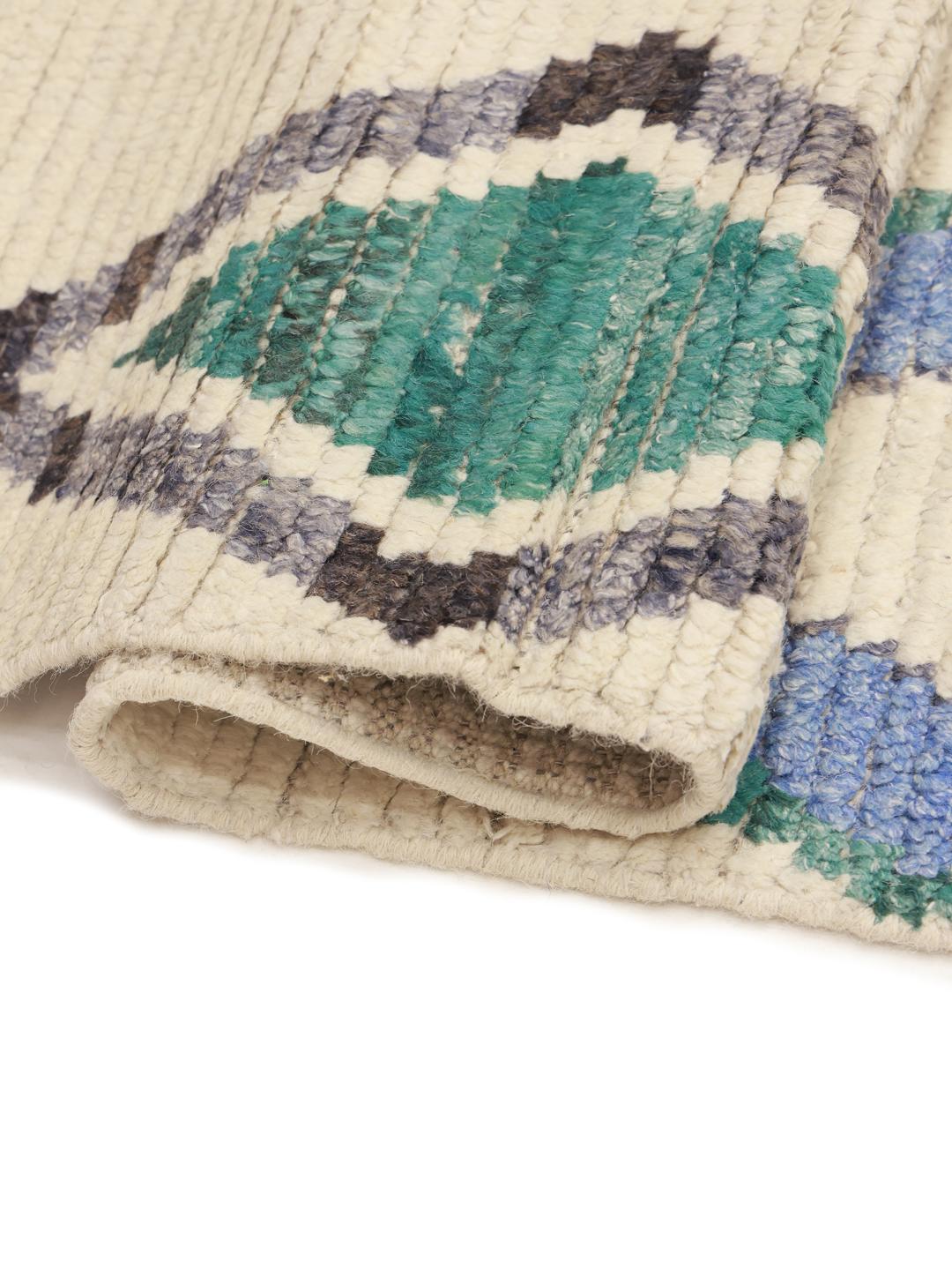 Hand-knotted Afghan rug with geometric diamond patterns in beige, blue, and green.