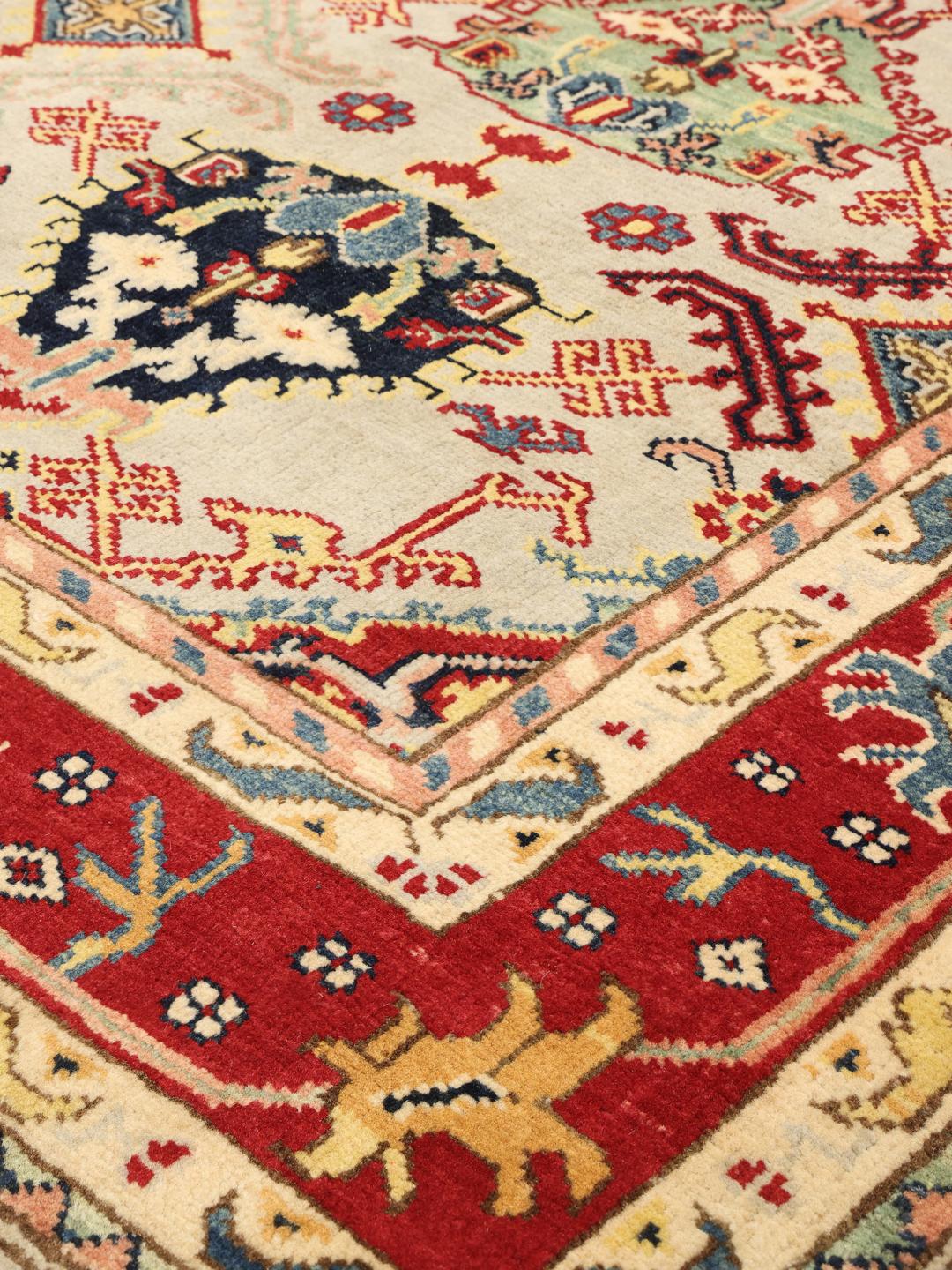 Tapis afghan noué à la main avec des motifs géométriques colorés sur un fond clair