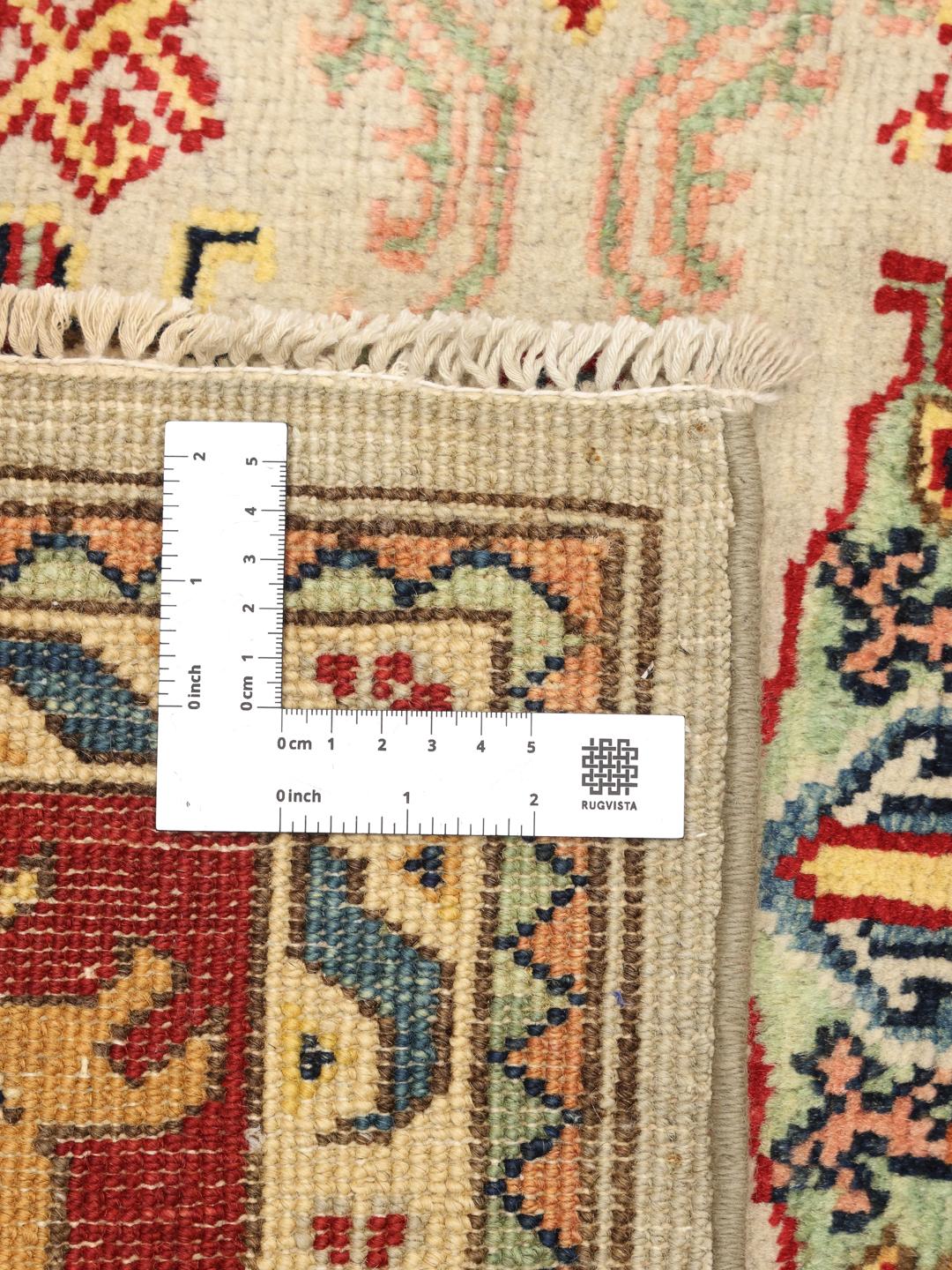 Tapis afghan noué à la main avec des motifs géométriques colorés sur un fond clair