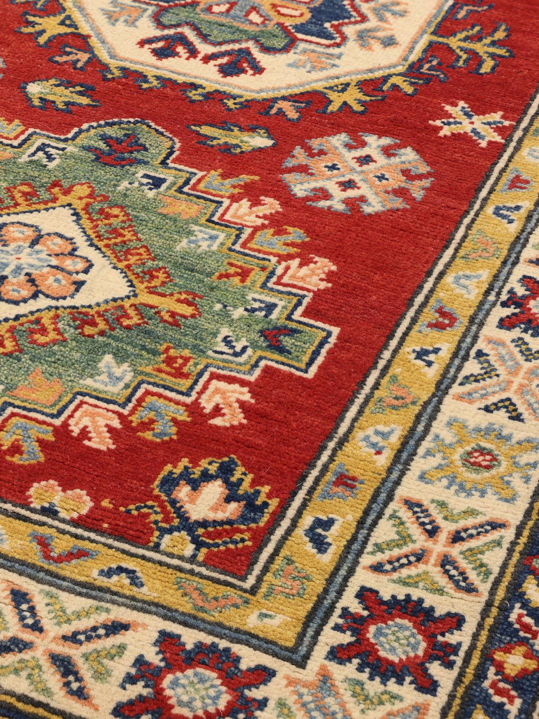 Tapis couloir afghan Kazak noué à la main avec un champ rouge vif et des motifs géométriques