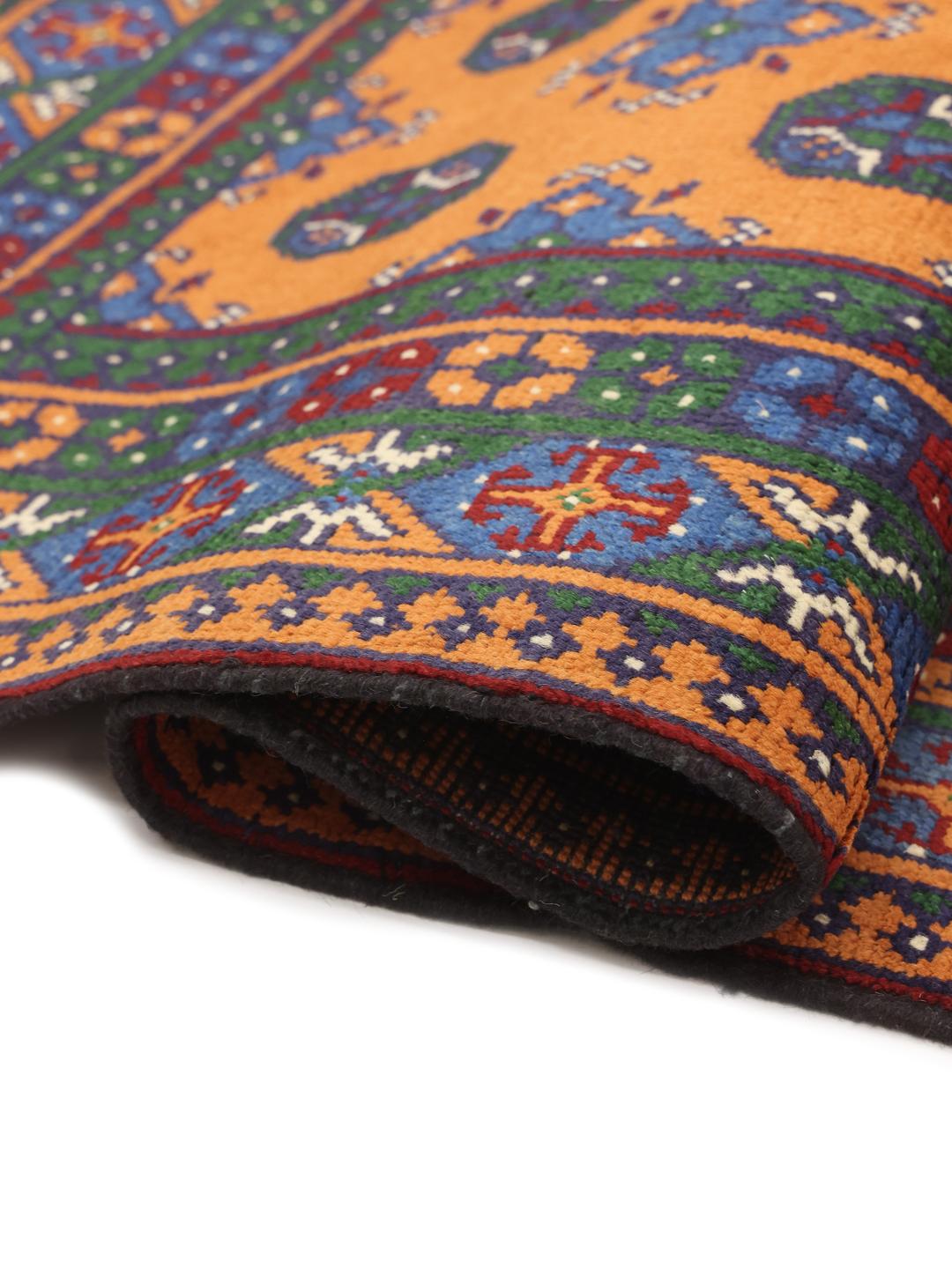 Hand-knotted Afghan rug with vibrant orange, blue, and green geometric tribal patterns.