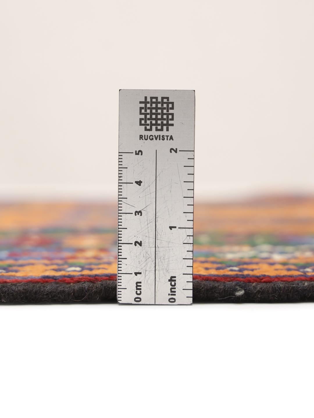 Hand-knotted Afghan rug with vibrant orange, blue, and green geometric tribal patterns.