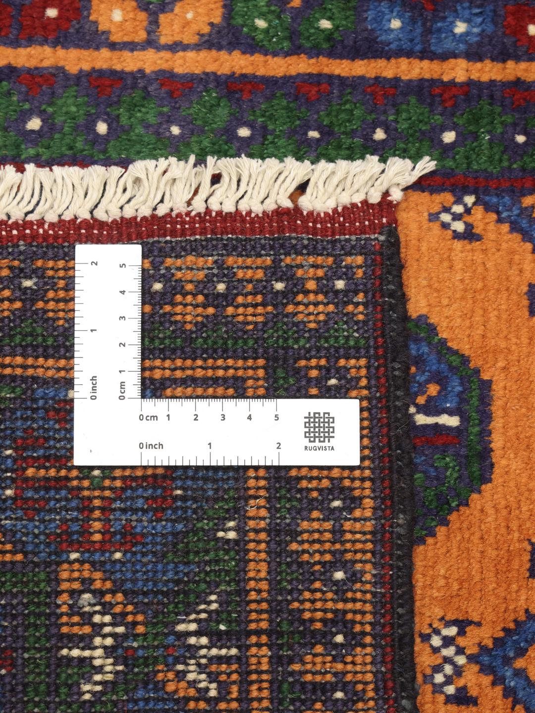 Hand-knotted Afghan rug with vibrant orange, blue, and green geometric tribal patterns.