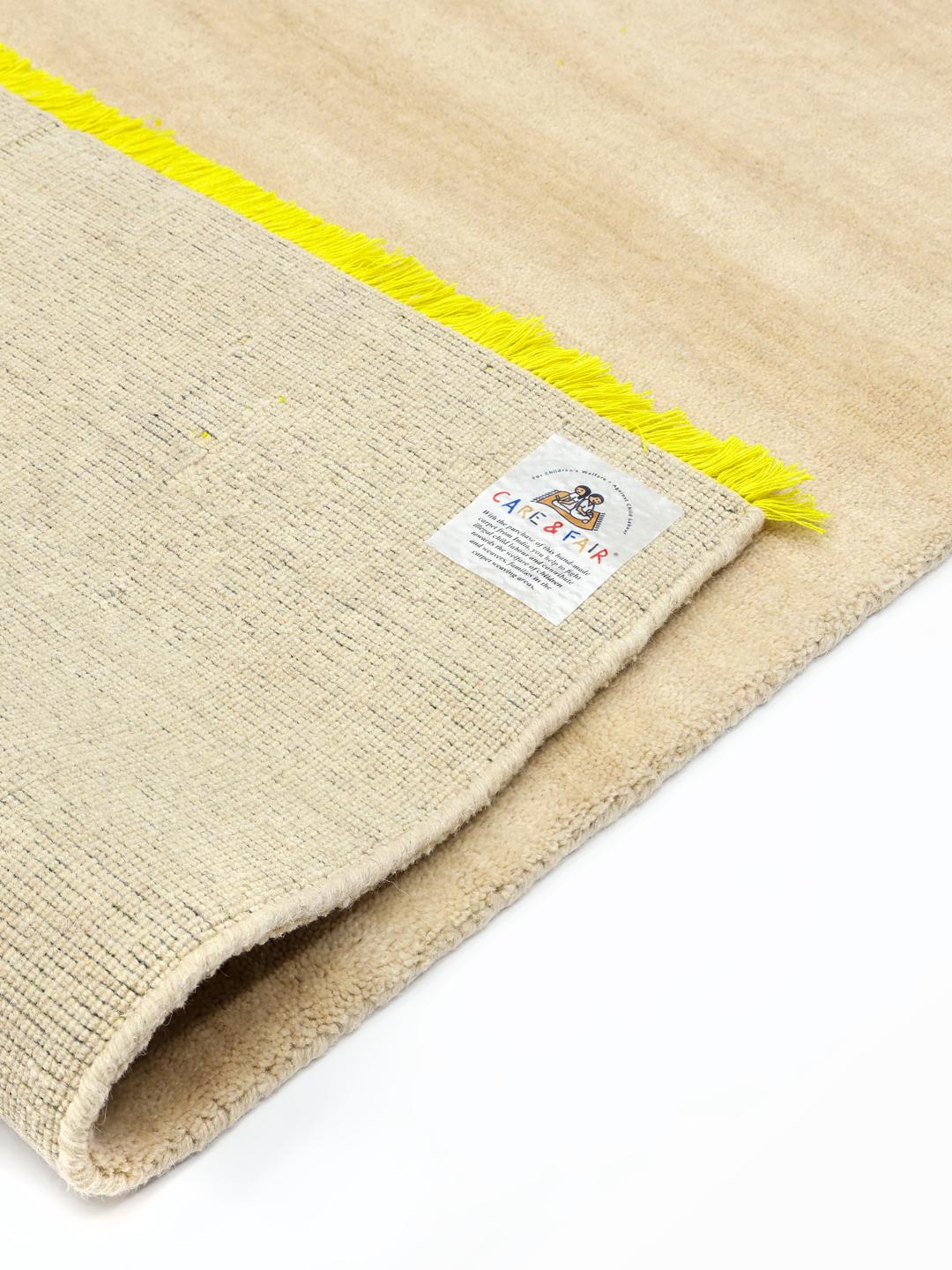 Beige wollen tapijt met levendige gele franjes