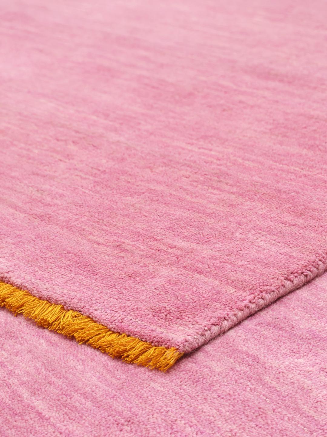 A pink and orange Wool rug with a soft texture.