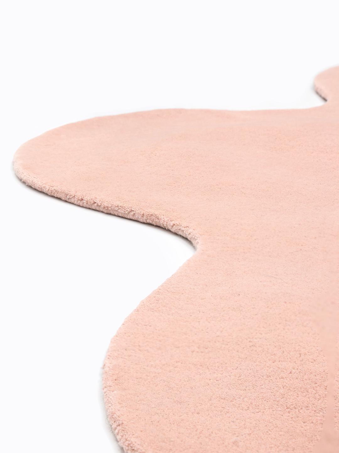 Onregelmatig roze tapijt met een zachte wollen pool