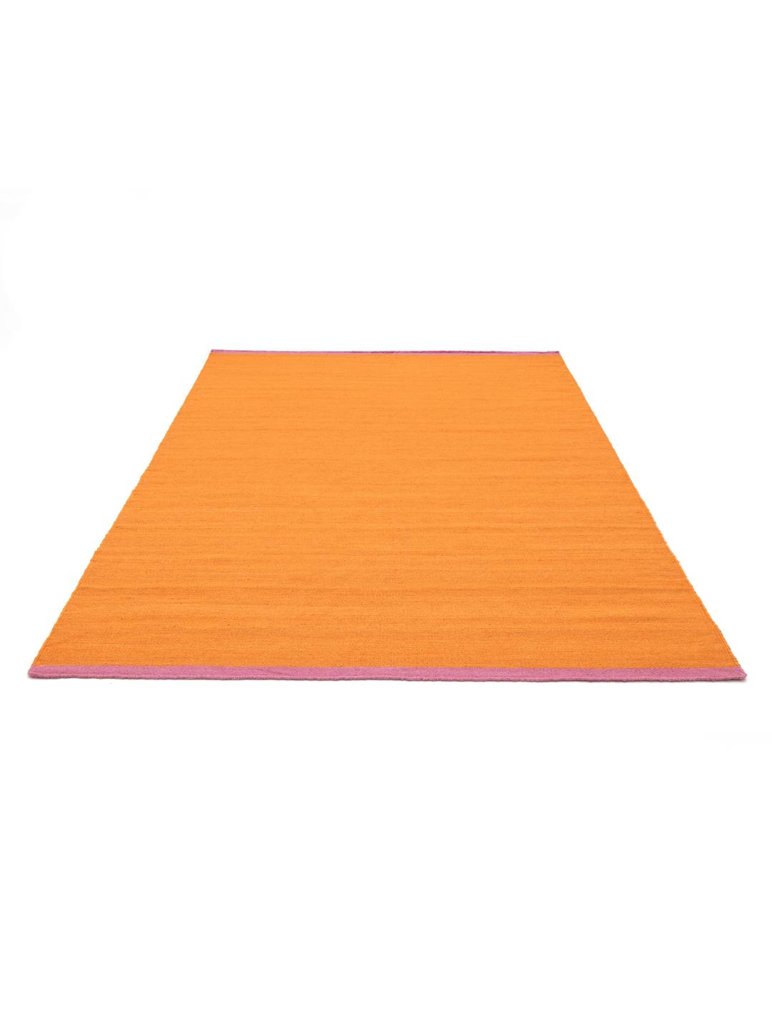 Un tapis rectangulaire en laine orange avec des bordures roses
