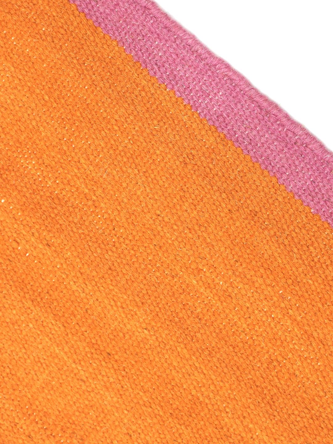 Un tapis rectangulaire en laine orange avec des bordures roses