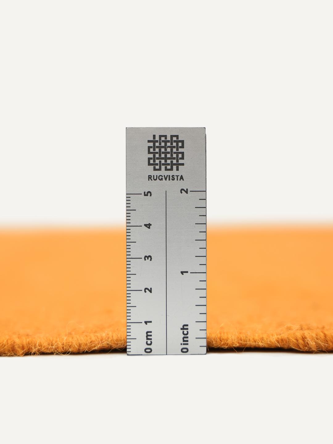Un tapis rectangulaire en laine orange avec des bordures roses