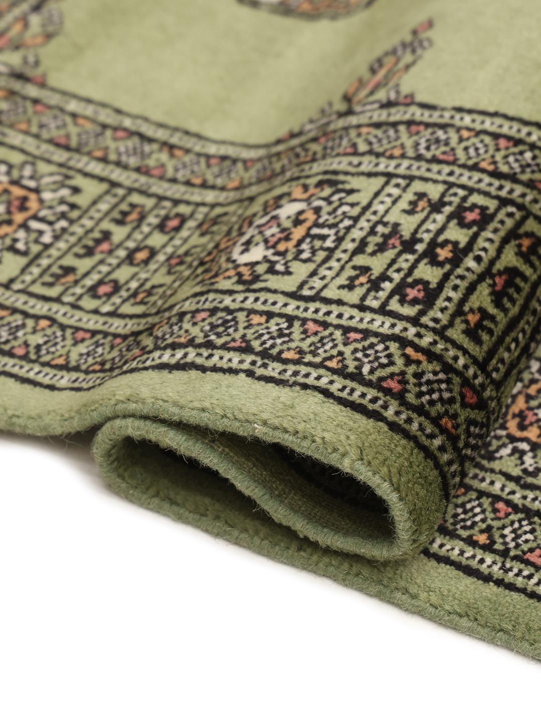 Hand-knotted Pakistan Bokhara runner in green with traditional geometric motifs.
