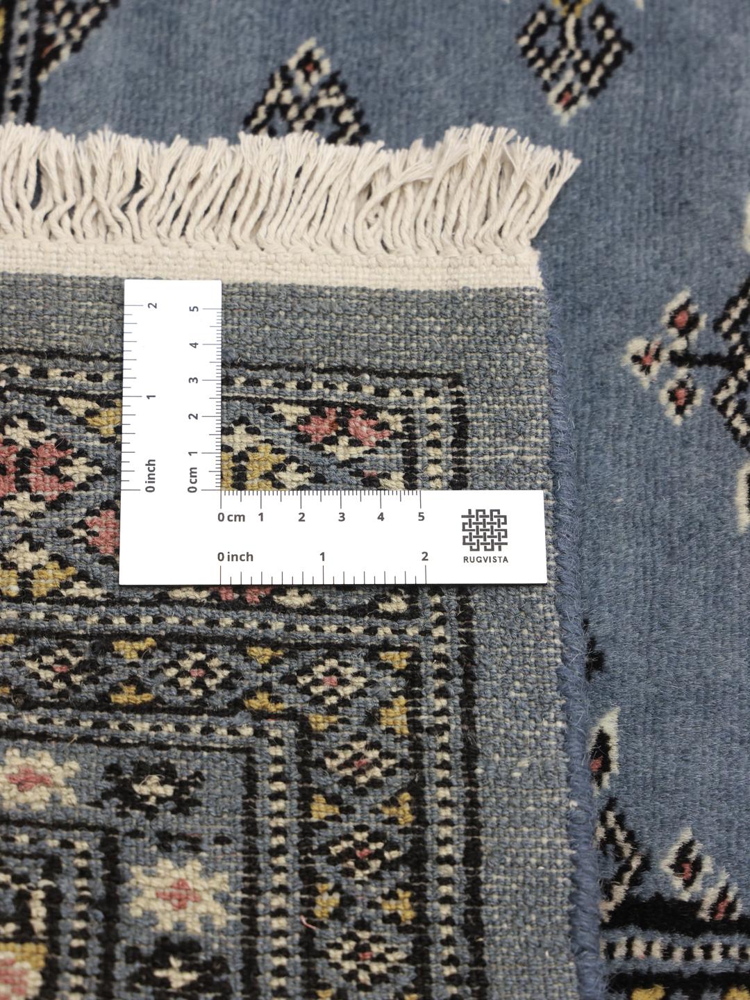 A hand-knotted Pakistan Bokhara rug in grey with traditional medallion motifs.