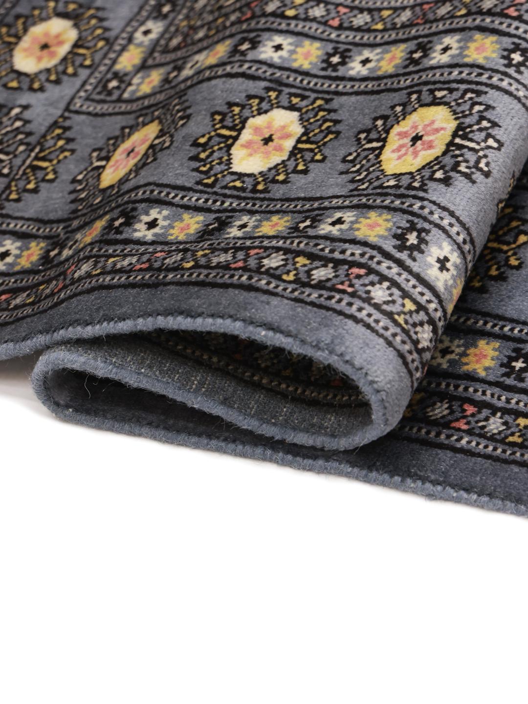 A hand-knotted Pakistan Bokhara rug in grey with traditional medallion motifs.