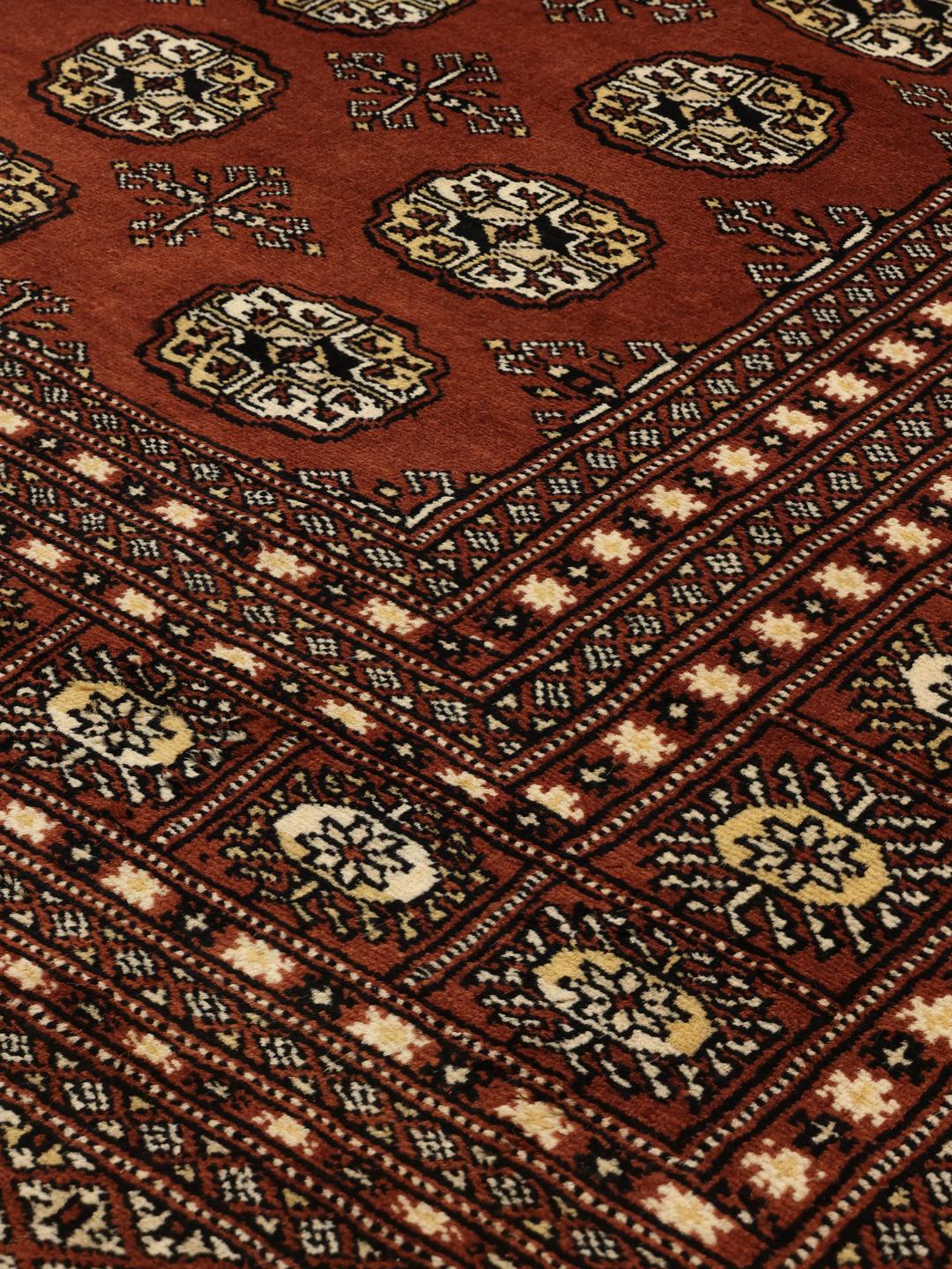 Hand-knotted Pakistani Bokhara rug in dark-red with traditional gul motifs