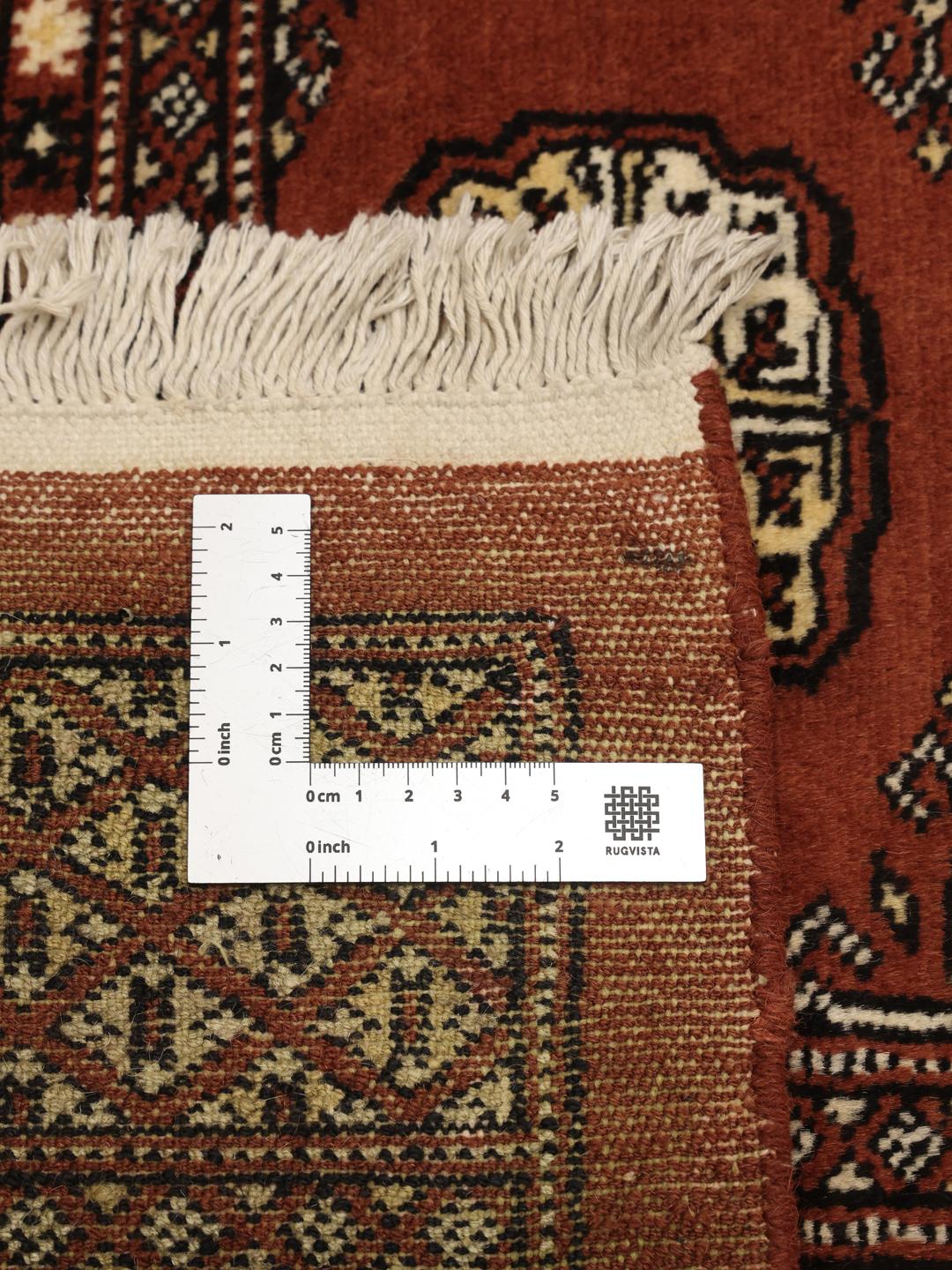 Hand-knotted Pakistani Bokhara rug in dark-red with traditional gul motifs