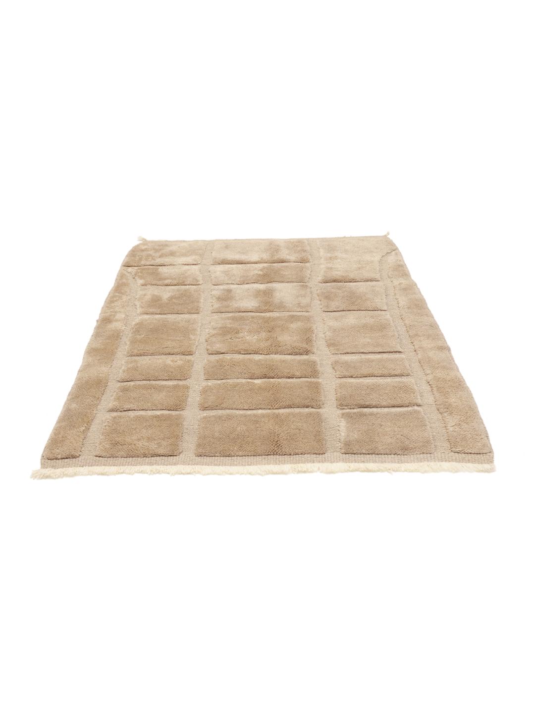 Un tapis berbère marocain noué à la main en beige avec un motif de grille géométrique.