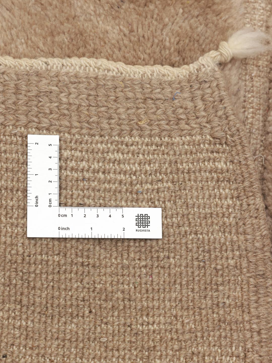 Un tapis berbère marocain noué à la main en beige avec un motif de grille géométrique.