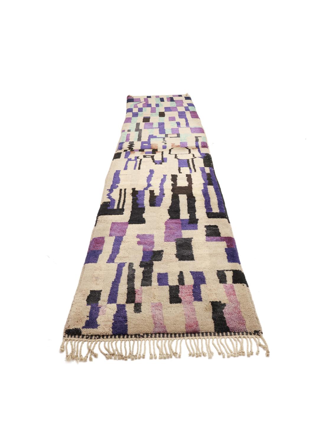Håndknyttet marokkansk løber med abstrakte lilla, blå og sorte geometriske mønstre på en beige baggrund.