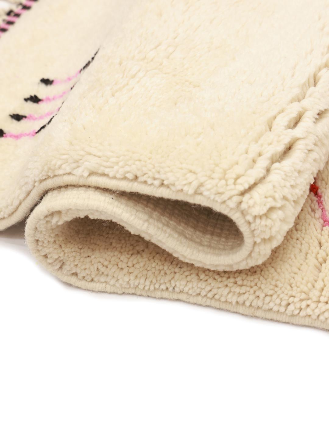 Handgeknoopt Marokkaans Beni Ourain-tapijt met tribale symbolen op een beige wollen achtergrond.