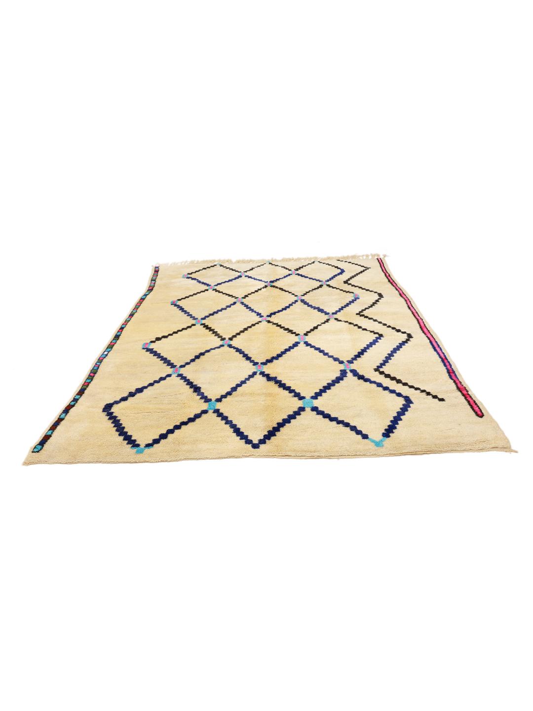 Een met de hand geknoopt Berber Marokkaans tapijt met een geometrisch ruitpatroon in blauw en zwart op een beige wollen achtergrond.