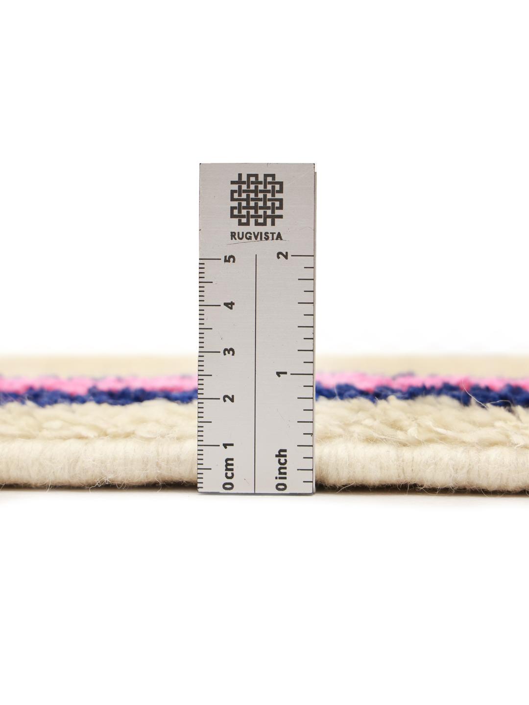 Een met de hand geknoopt Berber Marokkaans tapijt met een geometrisch ruitpatroon in blauw en zwart op een beige wollen achtergrond.