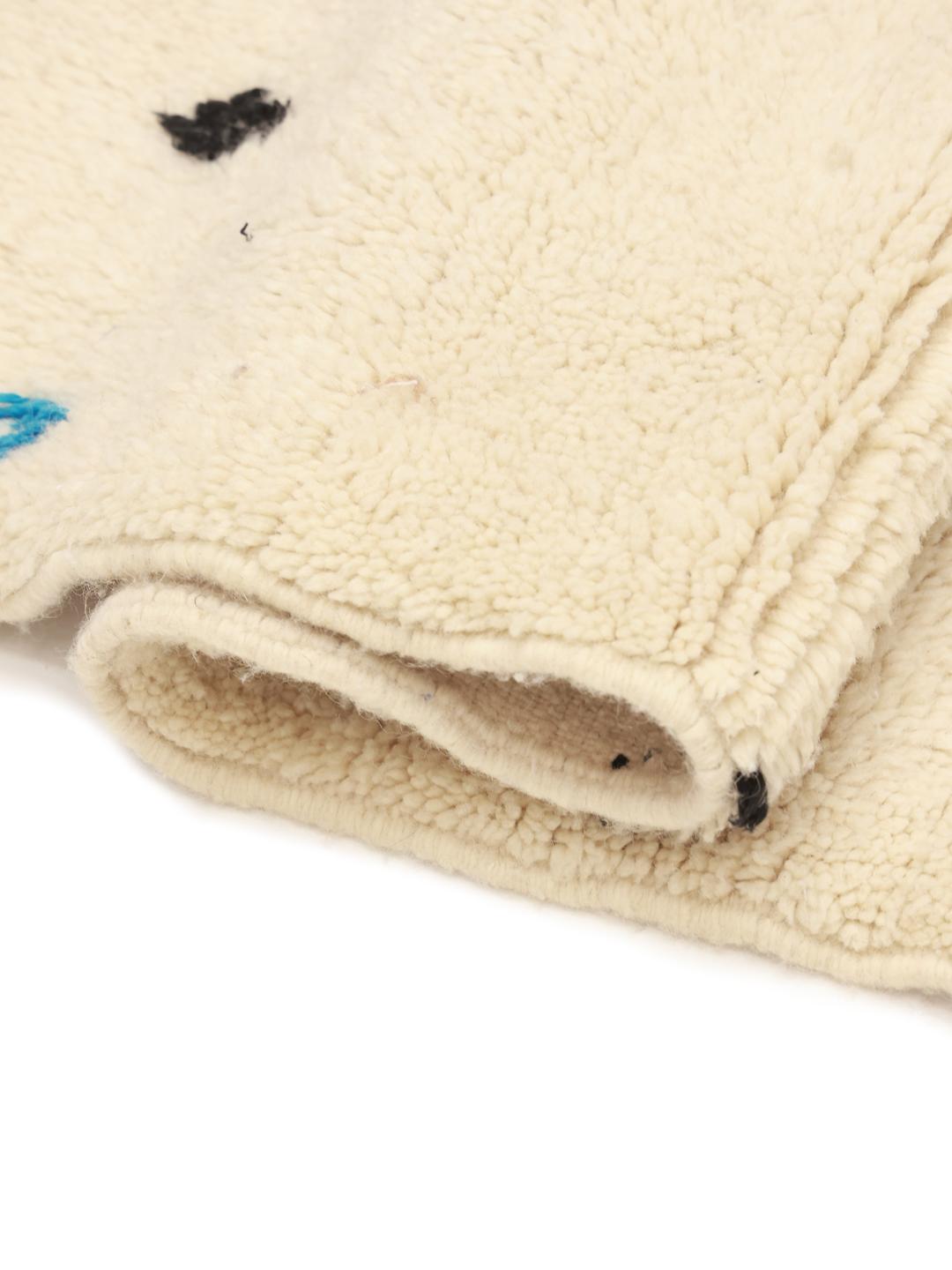 Een handgeknoopt Berber Marokkaans tapijt uit de Midden-Atlas met een beige pool en kleurrijke geometrische patronen.