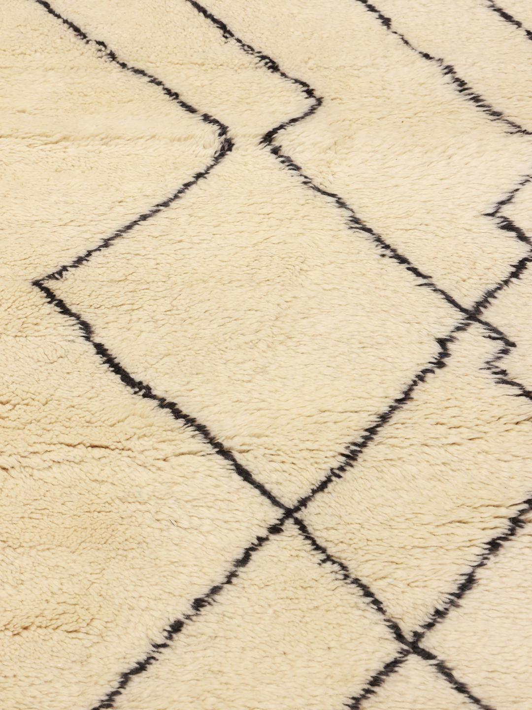 Handgeknoopt Marokkaans Beni Ourain-vloerkleed met een geometrisch patroon in beige en zwart.