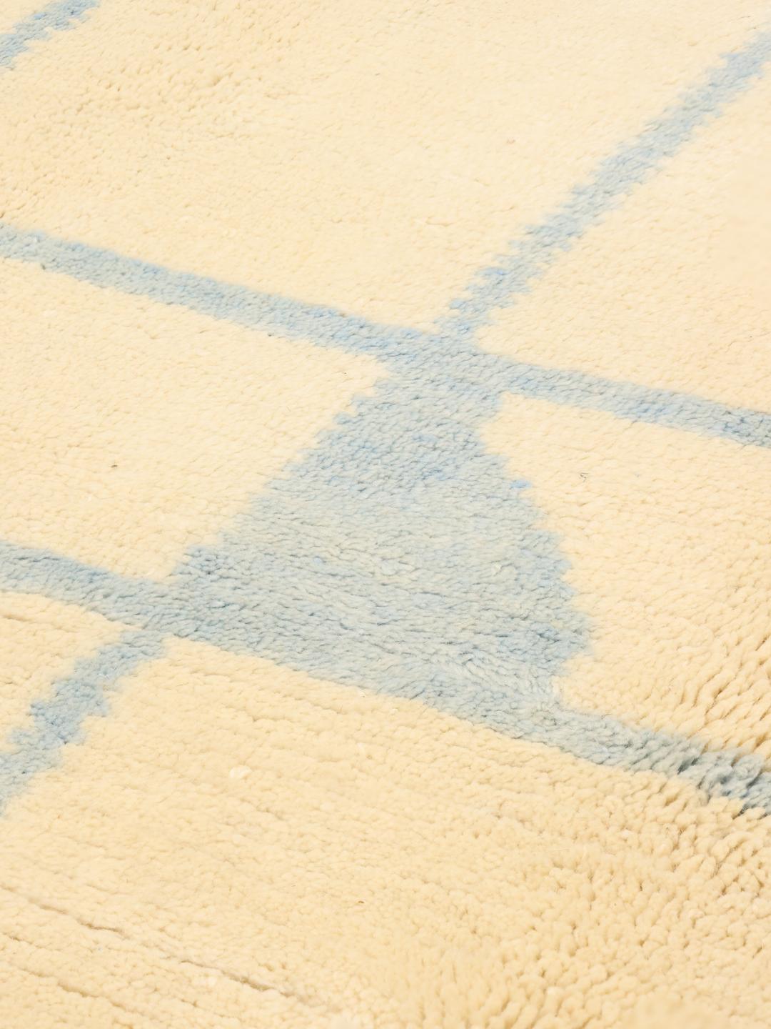 Handgeknoopt Marokkaans tapijt met een blauw ruitpatroon op een beige wollen achtergrond