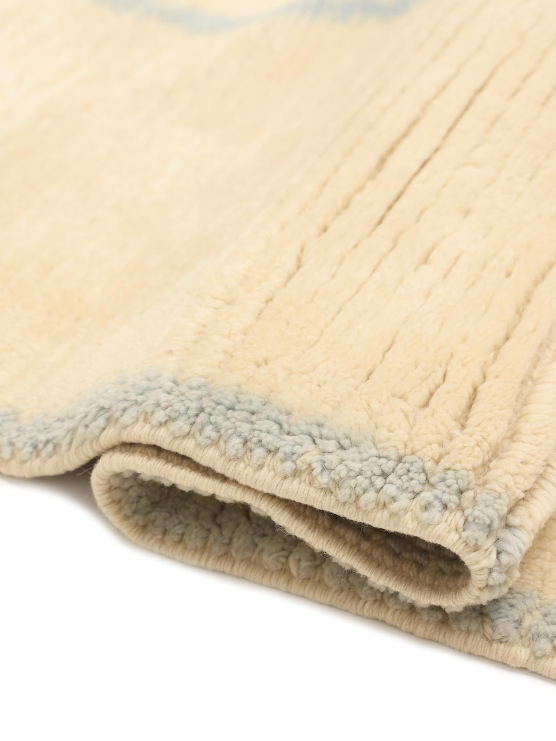 Handgeknoopt Marokkaans tapijt met een blauw ruitpatroon op een beige wollen achtergrond